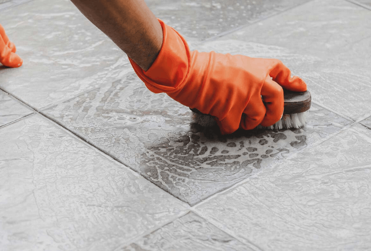 Person cleaning floor with brush